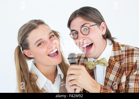 Felice geeky hipsters cantando con microfono Foto Stock