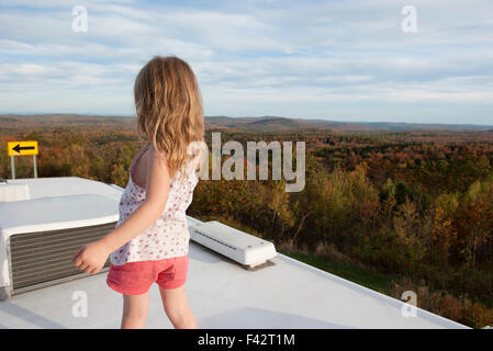 Bambina in piedi sulla parte superiore del motore home, guardando alla vista panoramica Foto Stock