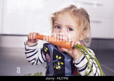 Bambina di mangiare una carota Foto Stock