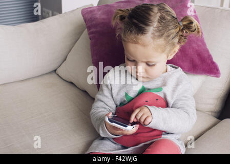 Bambina utilizza lo smartphone Foto Stock