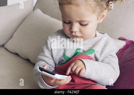 Bambina utilizza lo smartphone Foto Stock