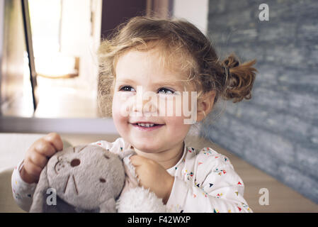 Bambina azienda giocattolo imbottito, sorridente, ritratto Foto Stock