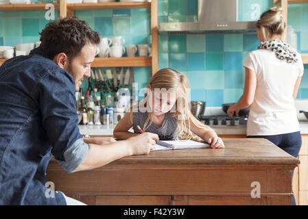 Padre aiutare mia figlia pratica di scrittura Foto Stock