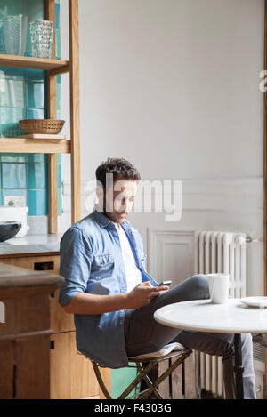 Uomo di inviare un messaggio di testo durante la pausa caffè Foto Stock