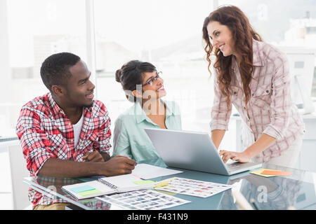 Il lavoro di squadra utilizzando laptop e editing di foto Foto Stock