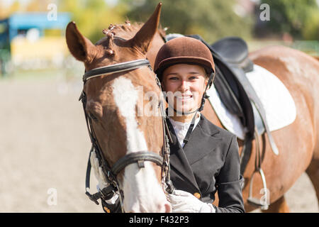 Giovane pilota sorridente ragazza con il suo cavallo Foto Stock