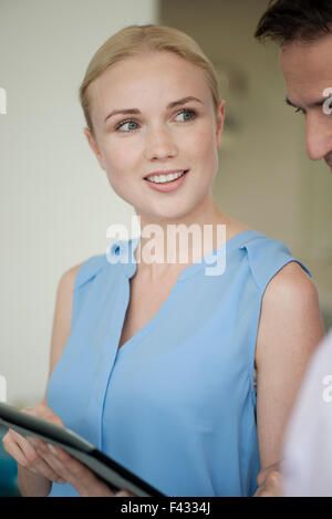 Imprenditrice che mostra digitale compressa a un collega Foto Stock