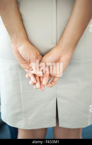 Donna di mani giunte, vista posteriore Foto Stock