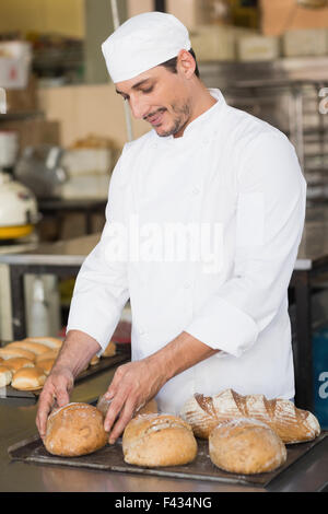 Baker controllando il pane appena sfornato Foto Stock