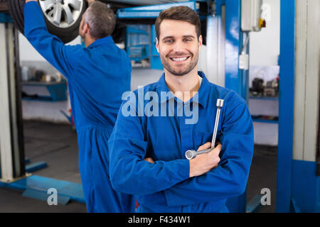 Mechanic sorridente verso la telecamera Foto Stock