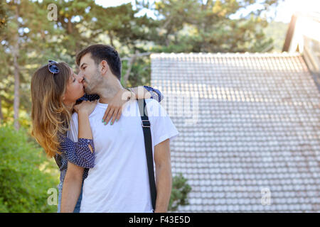 Giovane kissing davanti al resort di montagna Foto Stock