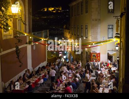 Lisbona, Portogallo - 23 ottobre 2014: persone aventi la cena all'aperto in Calcada do Duque a Lisbona, con il castello Sao Jorge in bac Foto Stock