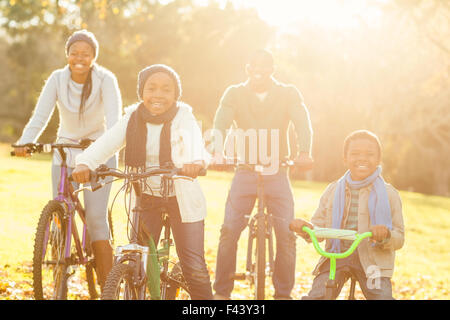 Giovane famiglia sorridente facendo un giro in bici Foto Stock