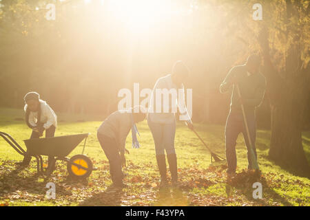 Famiglia giovane raccogliere le foglie Foto Stock