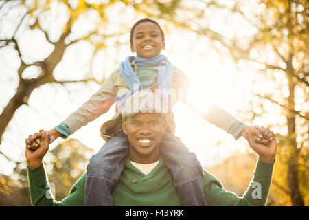 Ritratto di un padre con suo figlio in piggyback Foto Stock