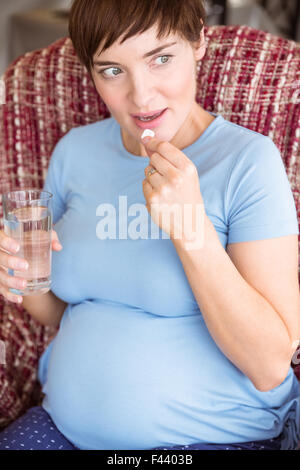 Donna incinta di prendere una compressa di vitamina Foto Stock