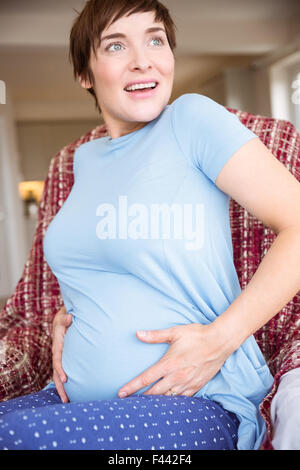 Donna incinta mentre tiene il suo bump Foto Stock