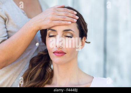 Donna ricevendo la terapia reiki Foto Stock