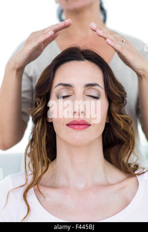 Donna ricevendo la terapia reiki Foto Stock