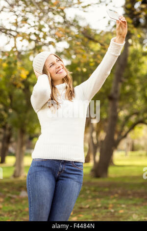 Sorridente donna graziosa tenendo selfies Foto Stock