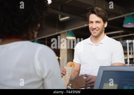 Il cliente di pagare il suo pane al cameriere Foto Stock