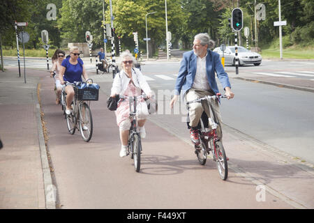 Donna anziana con gli altri in bici a L'Aia, Paesi Bassi. Foto Stock