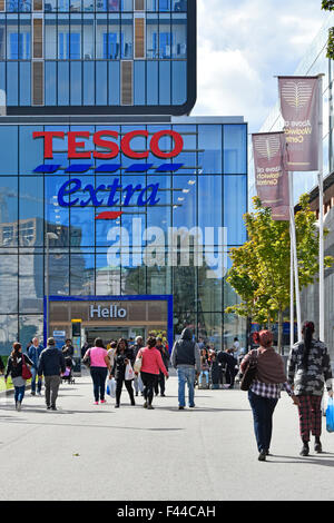 Gli amanti dello shopping a piedi verso Tesco supermercato Extra store parte del grande shopping & housing development a Woolwich Centro Sud Londra Inghilterra REGNO UNITO Foto Stock