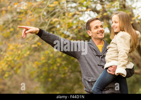 Padre mostrando qualcosa di sua figlia sorridente Foto Stock
