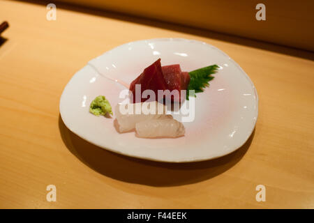 Tonno Sashimi hamachi wasabi e foglia di shiso su una piastra Foto Stock