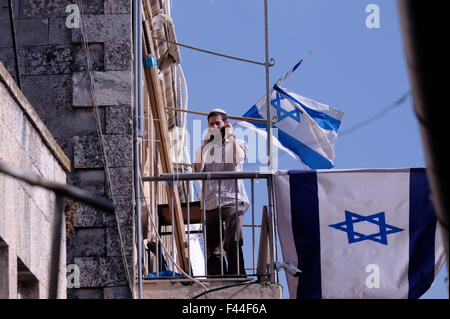 Un sedimentatore ebraica è visto in un balcone in una casa di coloni Ebrei ha assunto in Al Borra street che israeliani chiamata Aggeo Street nel Quartiere Musulmano di Gerusalemme la città vecchia, Israele Foto Stock