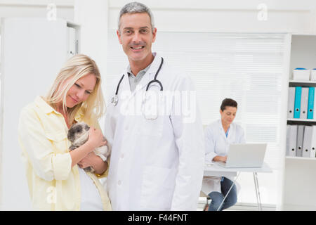 Veterinario e proprietario di gatti sorridente in telecamera Foto Stock