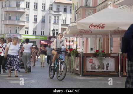 Giovane donna corse la sua bici attraverso la Città Vecchia nel centro di Zielona Gora, Polonia. Foto Stock