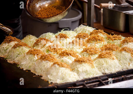 Okonomi giapponese-yaki con la sua pasta di soba sulla sommità di cavolo nero Foto Stock