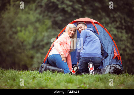 Coppia felice impostazione della loro tenda Foto Stock