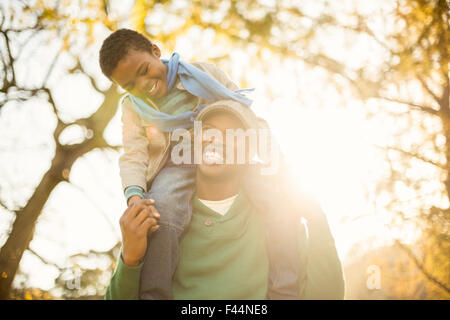 Ritratto di un padre con suo figlio in piggyback Foto Stock