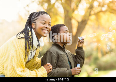 Little Boy facendo alcune bolle con sua madre Foto Stock