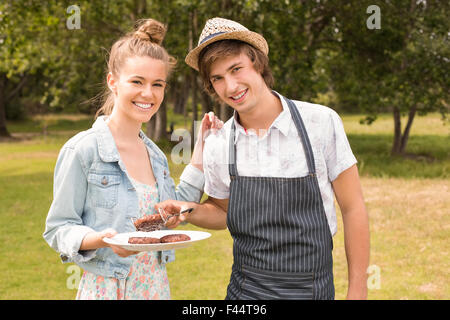 Happy amici nel parco con barbecue Foto Stock