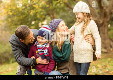 Sorridente giovane famiglia in posa insieme Foto Stock