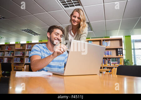 Studente ottenere aiuto dal tutor in biblioteca Foto Stock