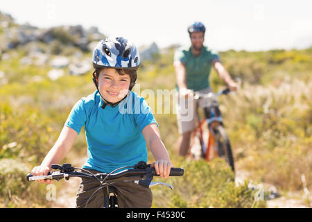 Padre e figlio in bici attraverso le montagne Foto Stock