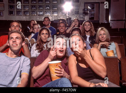 Mostra diverse emozioni, un gruppo multirazziale di studenti delle scuole superiori per guardare un filmato in campus Mission Viejo, CA. Nota popcorn. Foto Stock