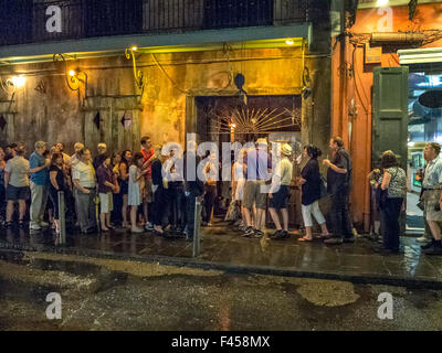 In una notte bagnata, multirazziale gli amanti del jazz la linea fino a entrare in New Orleans' famosi musical venue Hall di conservazione su San Pietro Street nella città del Quartiere Francese. Foto Stock