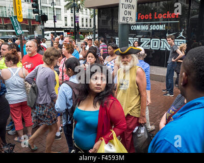 Un eclettico multirazziale folla attende per un carrello sul Canal Street a New Orleans. Foto Stock