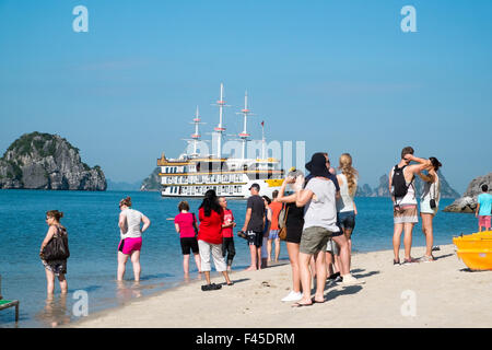 I turisti dalla leggenda del drago una barca sulla spiaggia di Cang fare isola, Bai Tu Long Bay in Halong Bay, il Vietnam Asia Foto Stock