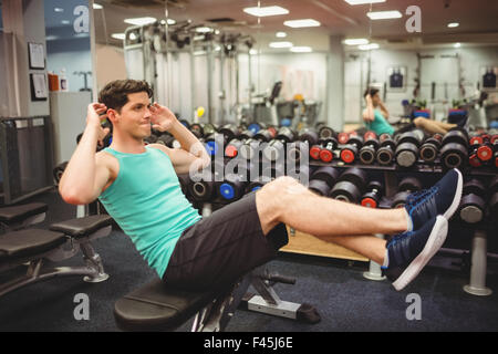 Montare l'uomo facendo sit ups Foto Stock