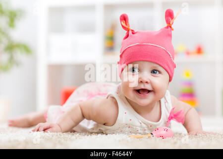 Carino baby in hat sul letto avente fun Foto Stock