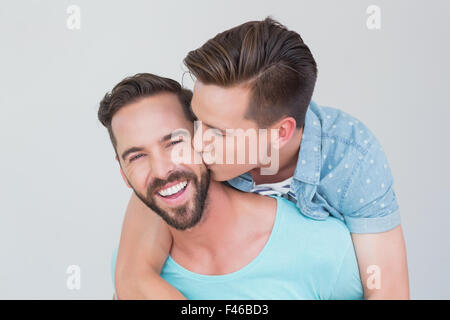 Felice coppia omosessuale baciare e con piggy back Foto Stock