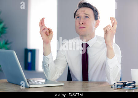 Uomo d'affari che desiderano attraversare le sue dita Foto Stock