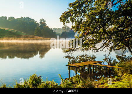 Nebbia autunnale oltre il lago a Bowood Station Wagon nel Wiltshire. Foto Stock