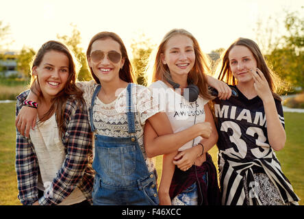 Un gruppo di ragazze adolescenti appendere fuori in un parco in un giorno di estate Foto Stock